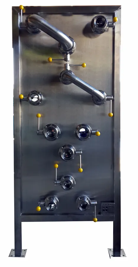 Flow Plates & Holding Tubes: Stainless steel flow plate with pipe connections and yellow valve caps